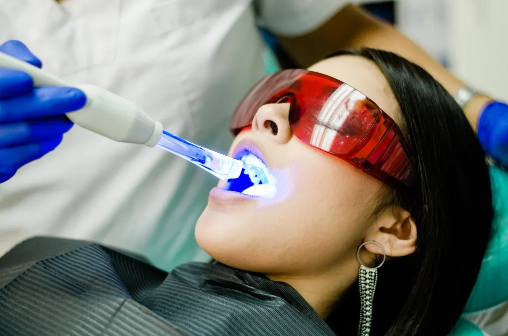 A patient wearing protective glasses during an in-office teeth whitening session (illustrative stock photo)